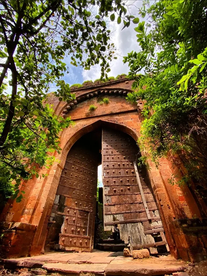 Historic arched fort gateway surrounded by greenery